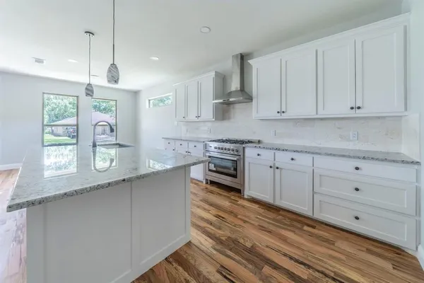 a kitchen with white cabinets and window