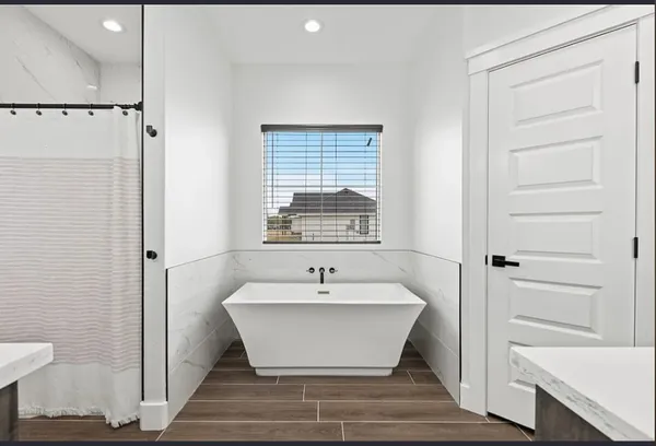 a view of a bathroom with a bathtub and shower