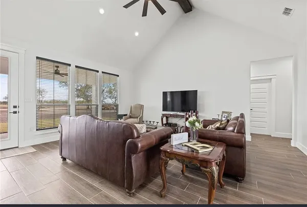 a living room with furniture a flat screen tv and a large window