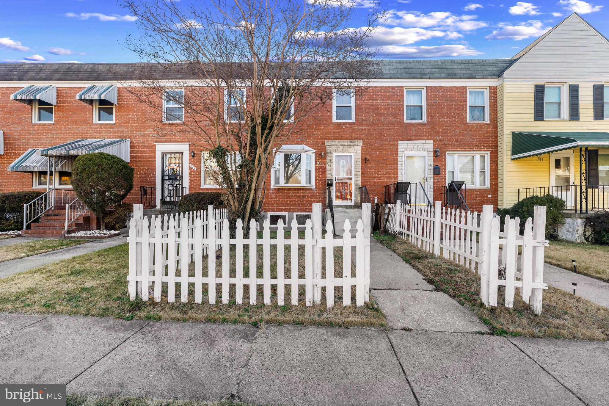 749 South Woodington Road Baltimore, MD 21229 - Photo 1 of 18 a front view of a brick house with a small yard