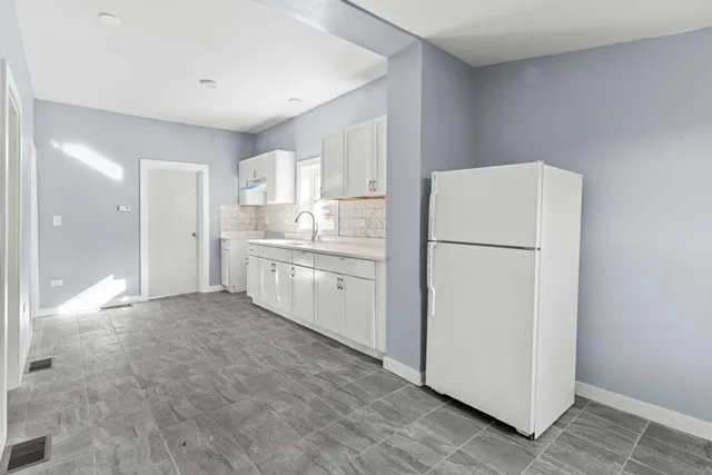 a kitchen with refrigerator cabinets and wooden floor