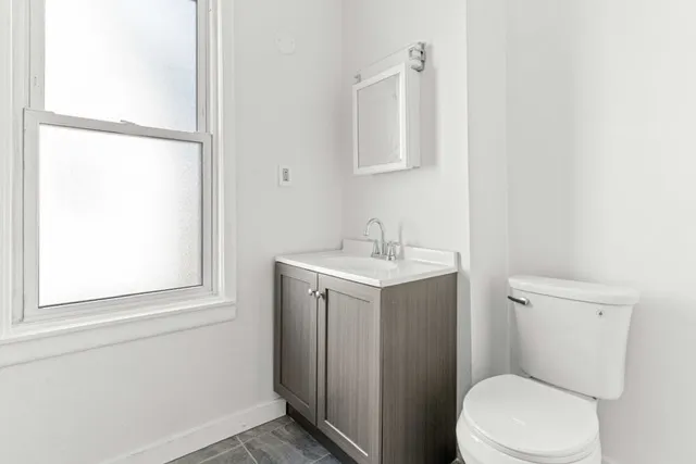 a white toilet sitting next to a bathroom sink