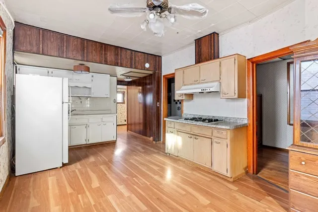 a kitchen with granite countertop a refrigerator and a stove top oven
