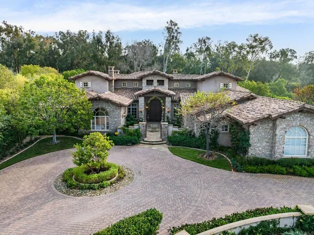 a front view of a house with a yard and potted plants