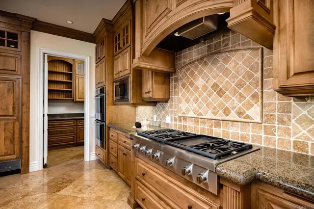 a kitchen with stainless steel appliances granite countertop a stove and a refrigerator