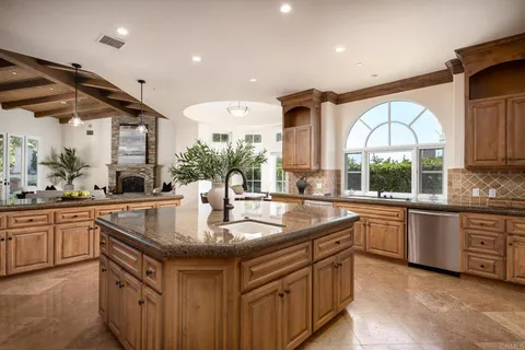 a kitchen with stainless steel appliances granite countertop a sink a stove and a wooden floors