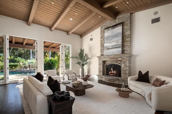 a living room with furniture large windows and fireplace
