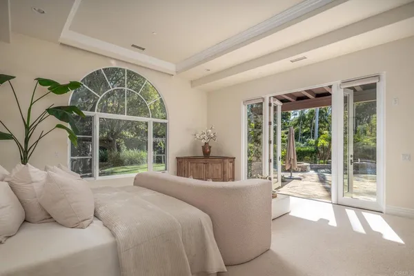 a bedroom with furniture and a large window