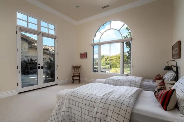a bedroom with a bed and a large window
