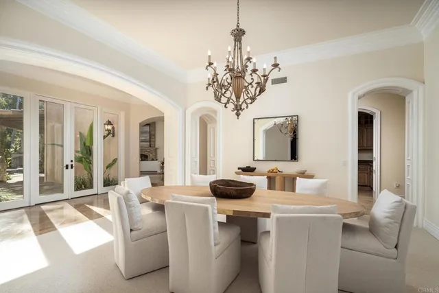 a dining room with chandelier and front door