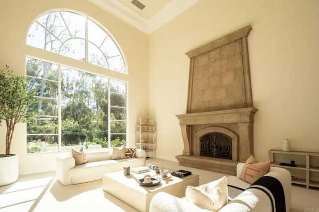 a living room with furniture a fireplace and a large window