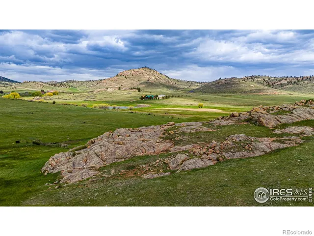 a view of a table and chairs in the grassy field