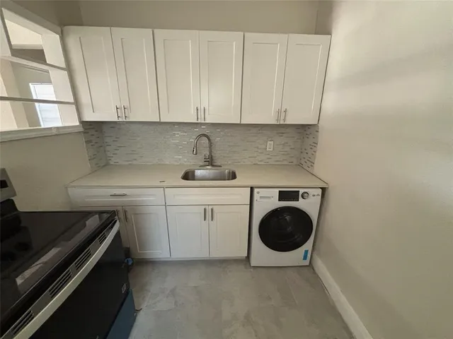 a kitchen with a sink a stove and cabinets