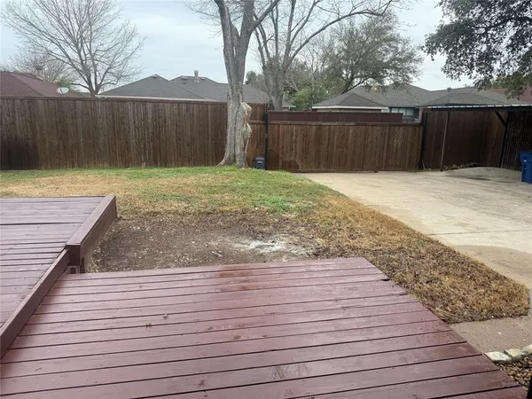a view of a backyard with wooden fence