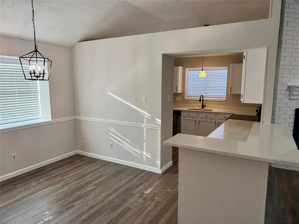 a kitchen with a sink a stove and wooden floor