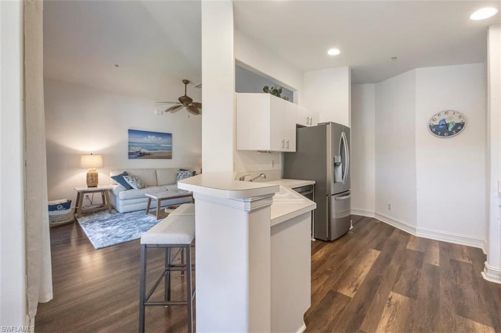 866 Carrick Bend Circle, Unit 201 Naples, FL 34110 - Photo 13 of 35 a living room with furniture a fireplace and a table