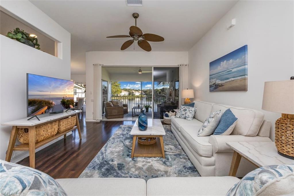 866 Carrick Bend Circle, Unit 201 Naples, FL 34110 - Photo 2 of 35 a living room with furniture and a flat screen tv