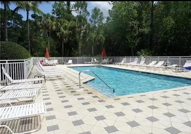 866 Carrick Bend Circle, Unit 201 Naples, FL 34110 - Photo 29 of 35 a view of a swimming pool with a lounge chair