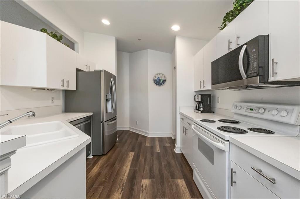 866 Carrick Bend Circle, Unit 201 Naples, FL 34110 - Photo 8 of 35 a kitchen with a sink a microwave a refrigerator and cabinets