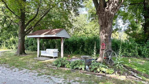 a backyard of a house with table and chairs under an umbrella