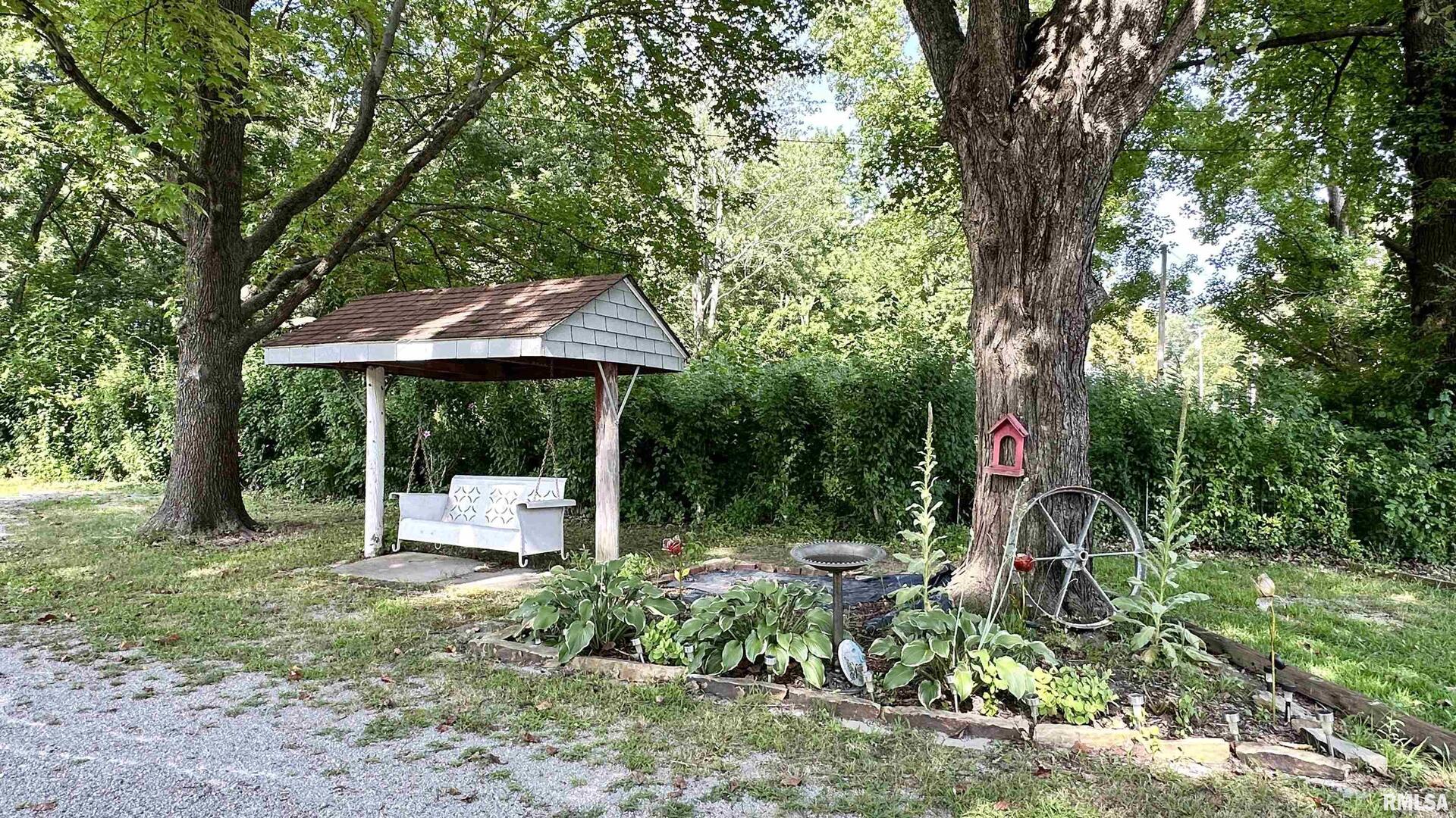 909 North Road West Frankfort, IL 62896 - Photo 6 of 28 a backyard of a house with table and chairs under an umbrella