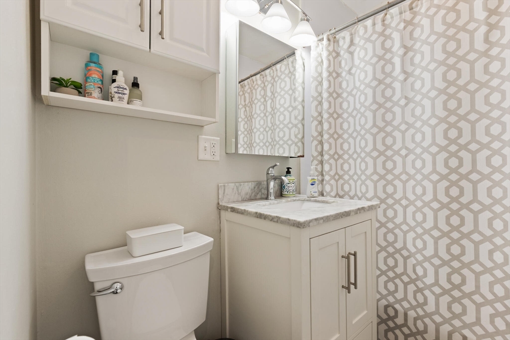 88 Gordon Street, Unit 402 Boston, MA 02135 - Photo 8 of 15 a bathroom with a sink a toilet and a mirror