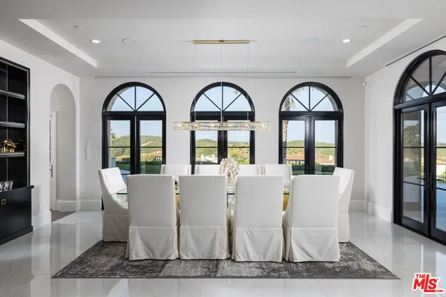 a large white building with glass windows and dining table