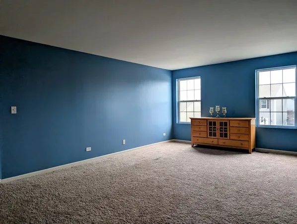an empty room with windows and cabinet
