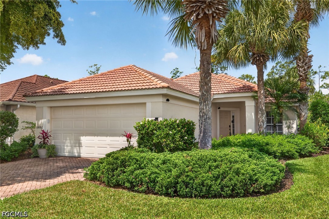 10082 Oakhurst Way Fort Myers, FL 33913 - Photo 1 of 50 a front view of a house with a garden and plants
