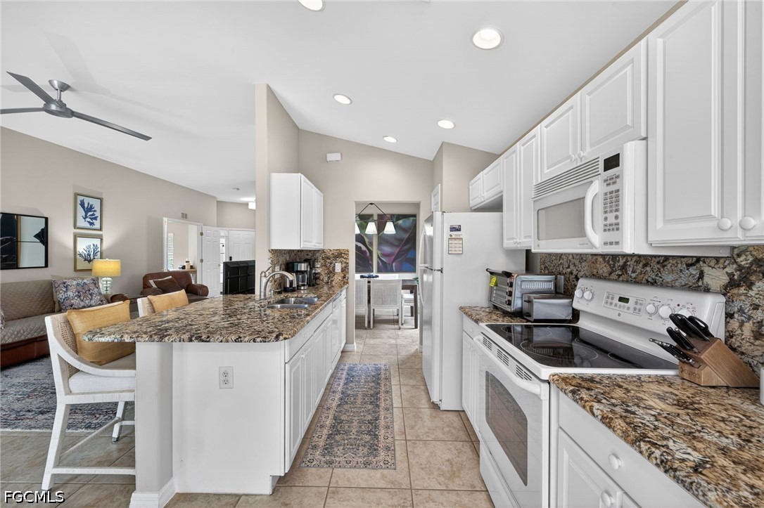 10082 Oakhurst Way Fort Myers, FL 33913 - Photo 12 of 50 a large kitchen with stainless steel appliances granite countertop a sink dishwasher a stove and a refrigerator with wooden floor