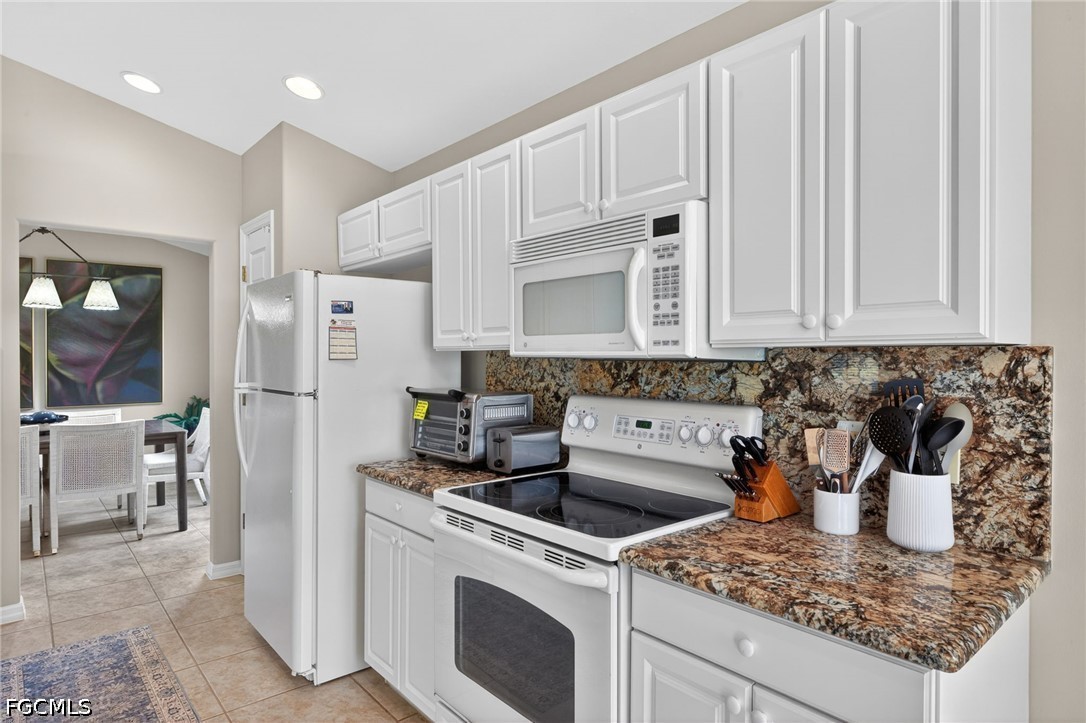 10082 Oakhurst Way Fort Myers, FL 33913 - Photo 13 of 50 a kitchen with stainless steel appliances granite countertop a sink stove and refrigerator