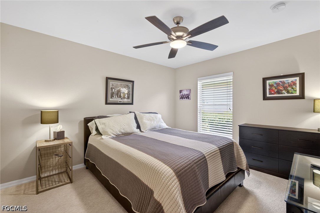 10082 Oakhurst Way Fort Myers, FL 33913 - Photo 21 of 50 a bedroom with a large bed and a chandelier