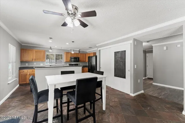 a dining area with a dining table chairs and refrigerator