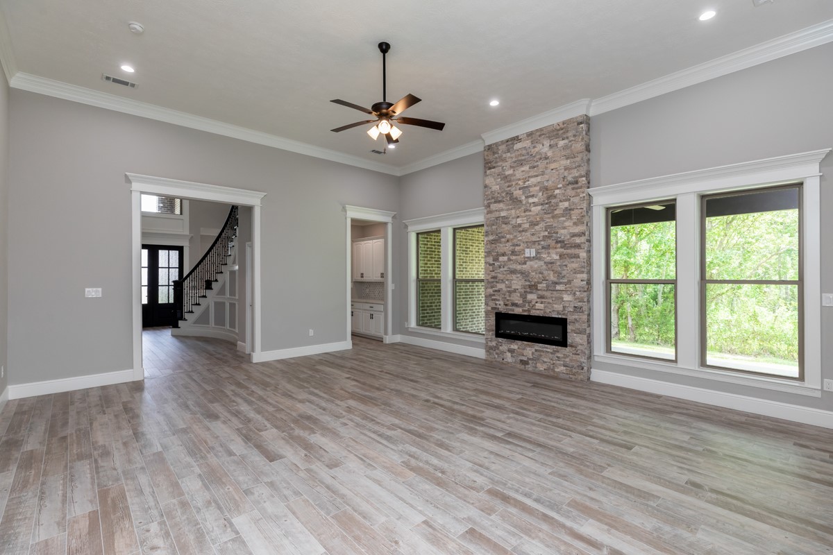 7705 Water Edge Beaumont, TX 77707 - Photo 15 of 39 a view of an empty room with wooden floor fireplace and a window