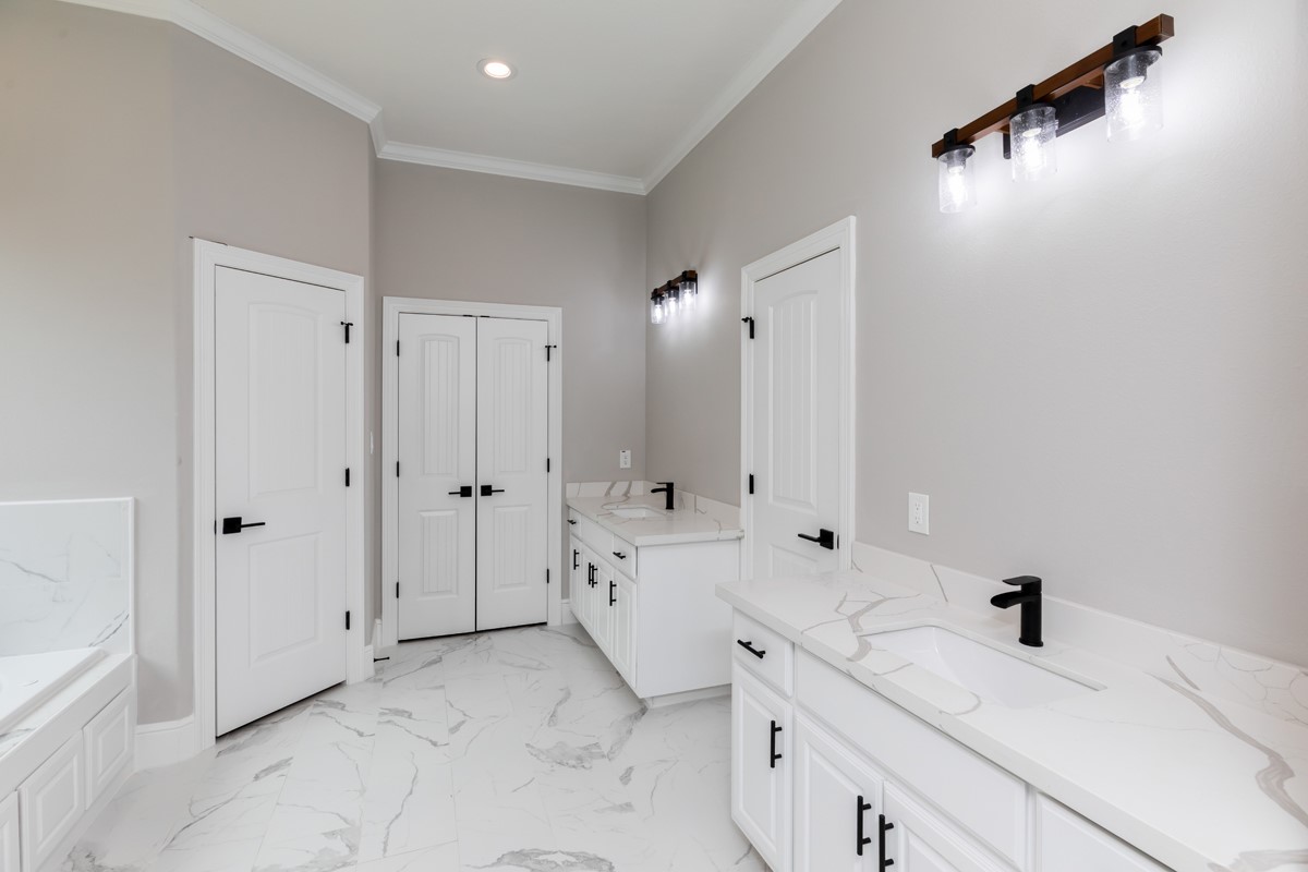 7705 Water Edge Beaumont, TX 77707 - Photo 20 of 39 a spacious bathroom with a double vanity sink a mirror and a bathtub