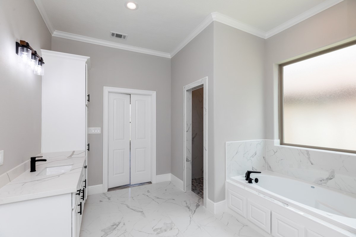 7705 Water Edge Beaumont, TX 77707 - Photo 22 of 39 a bathroom with a sink a mirror and a bathtub