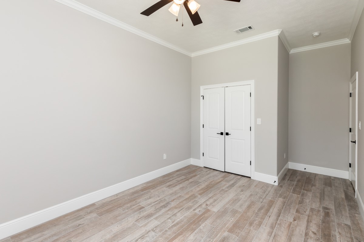7705 Water Edge Beaumont, TX 77707 - Photo 25 of 39 an empty room with a ceiling fan and wooden floor