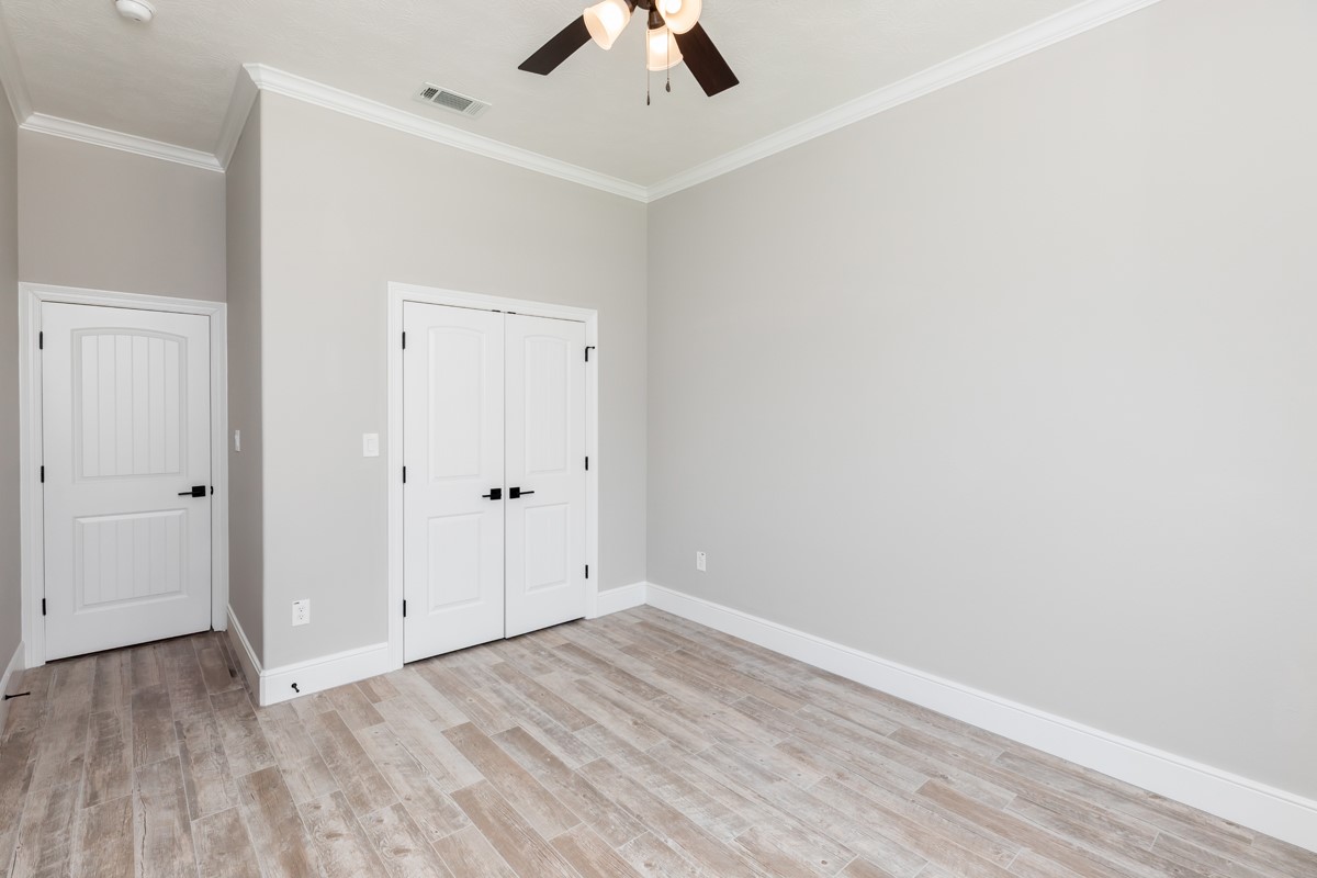 7705 Water Edge Beaumont, TX 77707 - Photo 28 of 39 an empty room with a ceiling fan and wooden floor