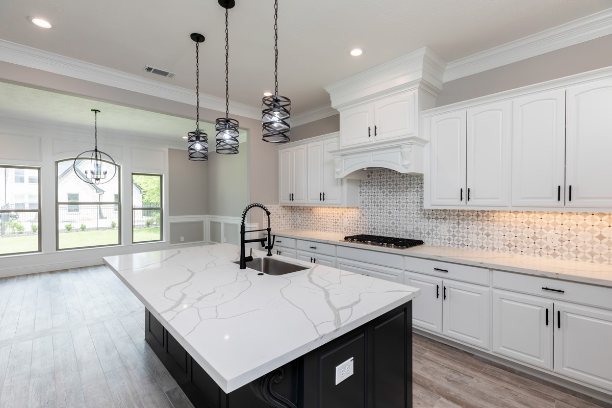7705 Water Edge Beaumont, TX 77707 - Photo 9 of 39 a kitchen with kitchen island granite countertop a sink a stove and cabinets
