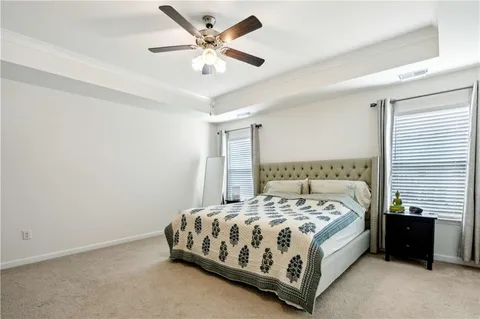a large bed sitting in a bedroom next to a window and a chandelier