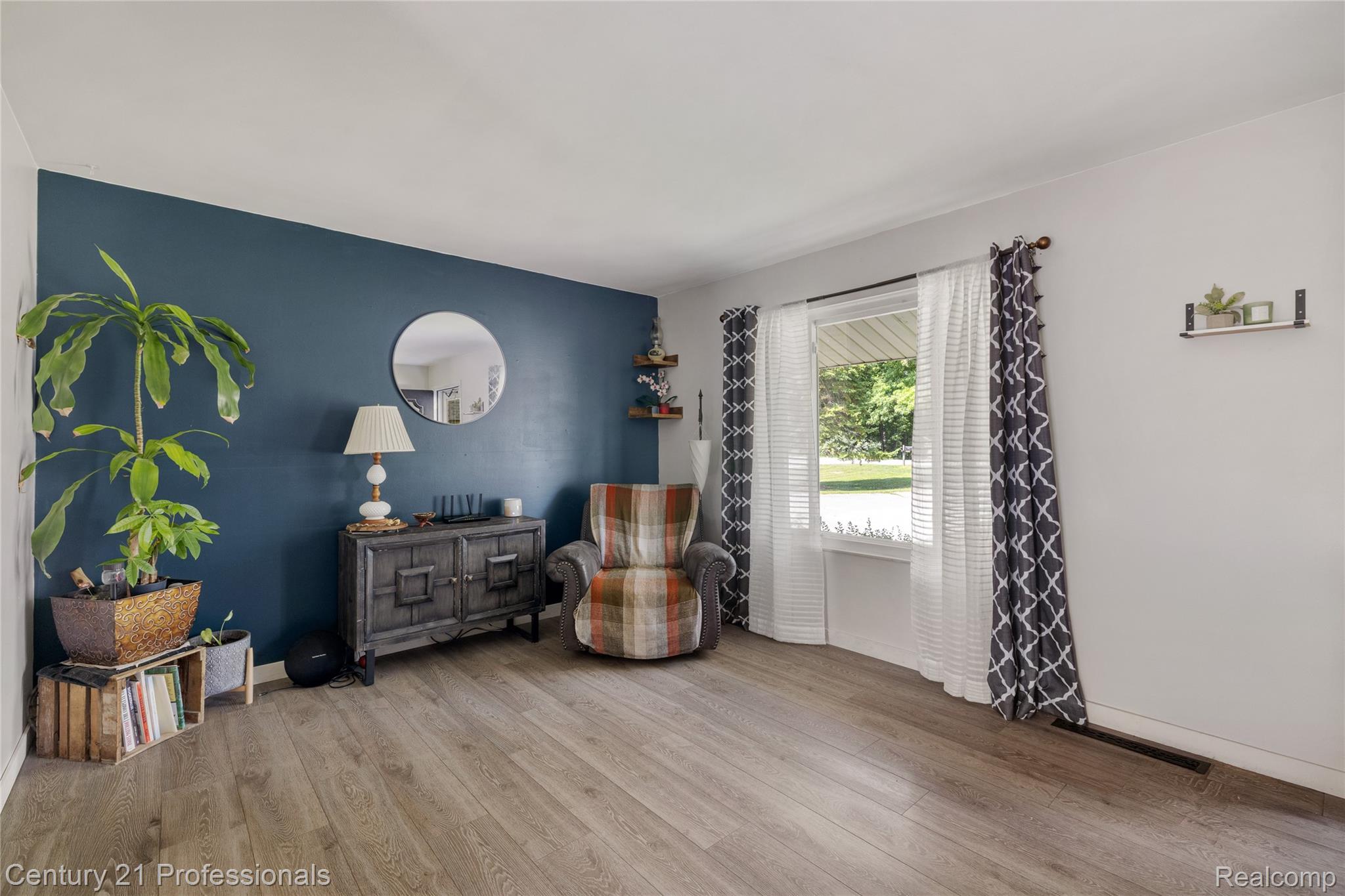 15037 Hogan Road Linden, MI 48451 - Photo 5 of 38 Wood-finish flooring throughout, complemented by a deep blue accent wall