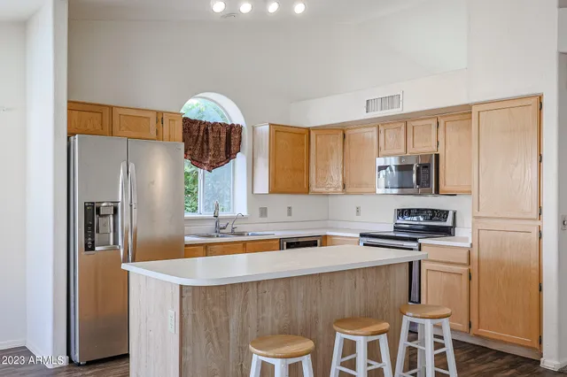 a kitchen with stainless steel appliances a sink a stove a refrigerator and cabinets