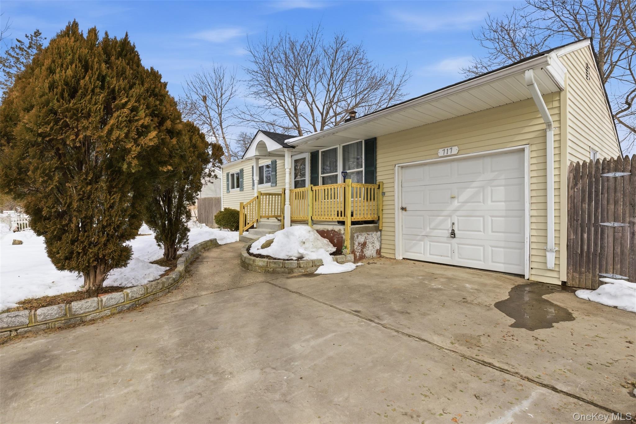 View of front of property with concrete driveway and an attached garage