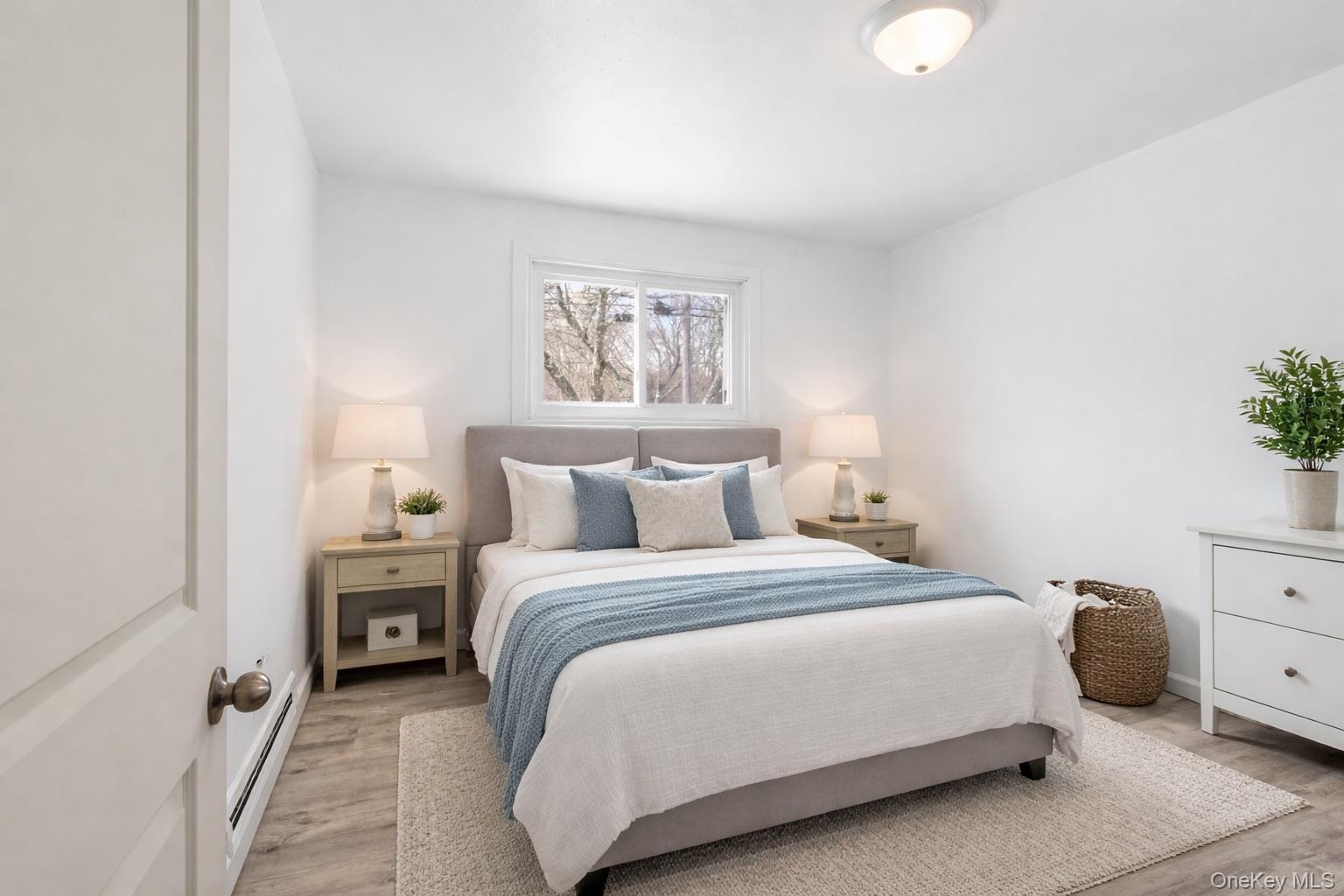 717 Doane Avenue Bellport, NY 11713 - Photo 12 of 22 Bedroom with baseboard heating and light wood-style floors