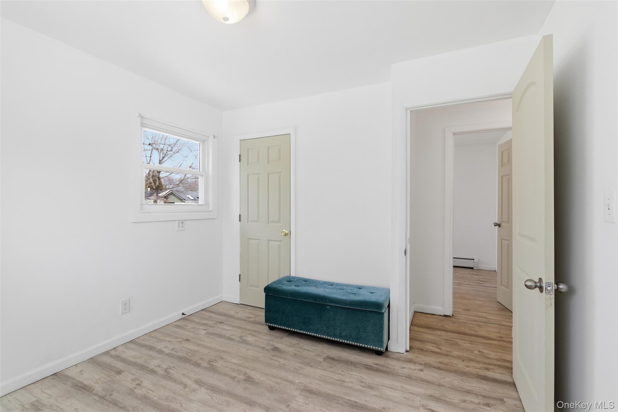 717 Doane Avenue Bellport, NY 11713 - Photo 14 of 22 Unfurnished bedroom featuring light wood-style floors and a baseboard radiator
