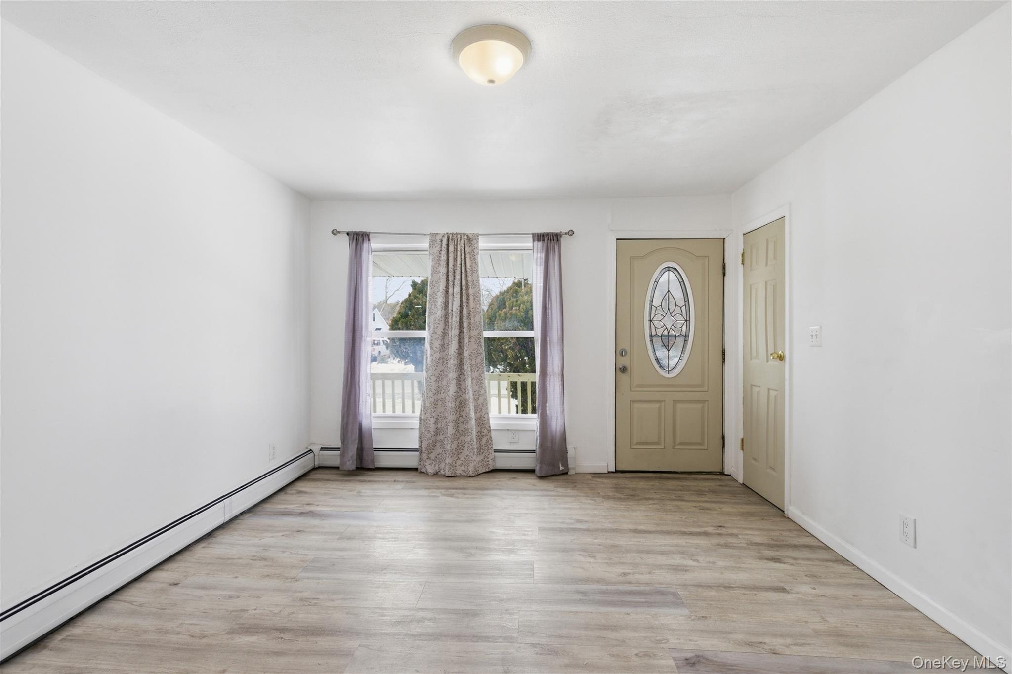 717 Doane Avenue Bellport, NY 11713 - Photo 8 of 22 Foyer entrance featuring a baseboard heating unit and light wood-type flooring