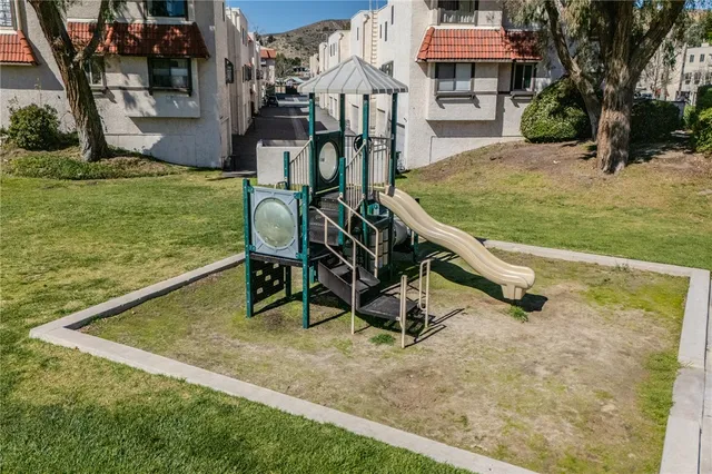 a view of a swimming pool with a patio and a yard
