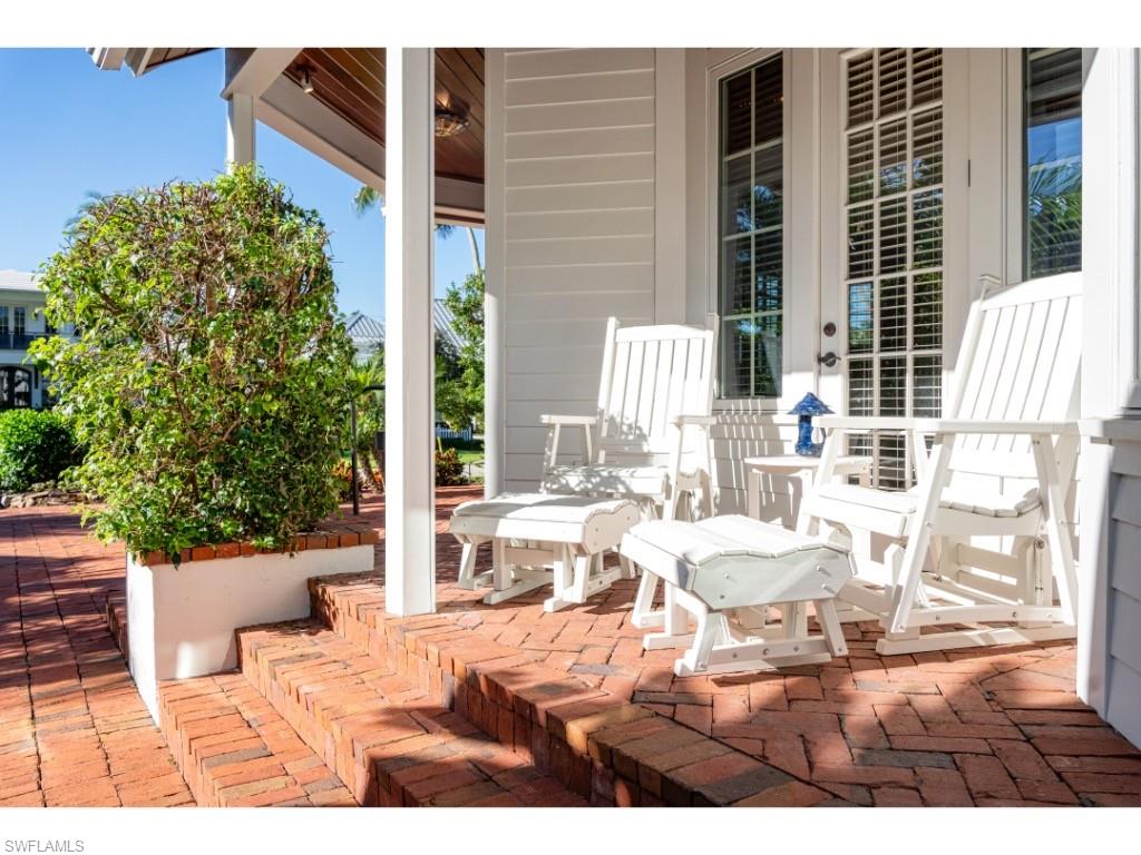 263 10th Avenue South Naples, FL 34102 - Photo 14 of 18 a view of a patio with a dining table and chairs
