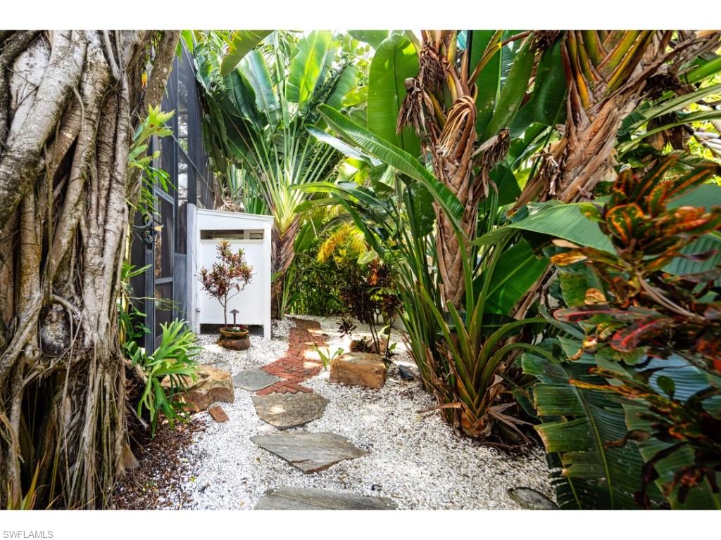 263 10th Avenue South Naples, FL 34102 - Photo 15 of 18 a backyard of a house with table and chairs