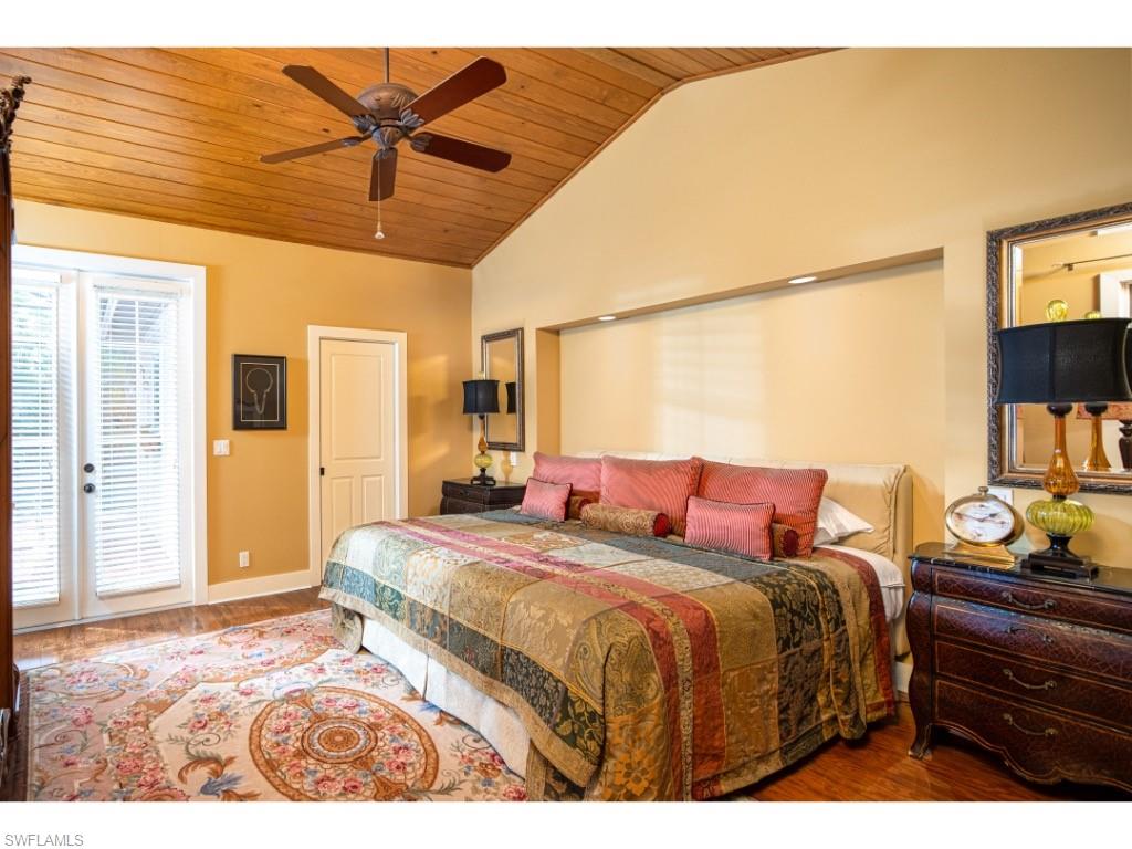 263 10th Avenue South Naples, FL 34102 - Photo 7 of 18 a bedroom with a bed and a chandelier